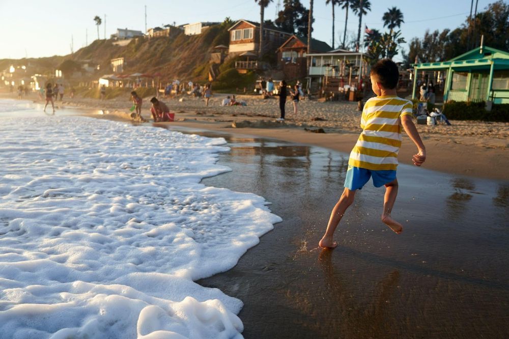 boy running from waves